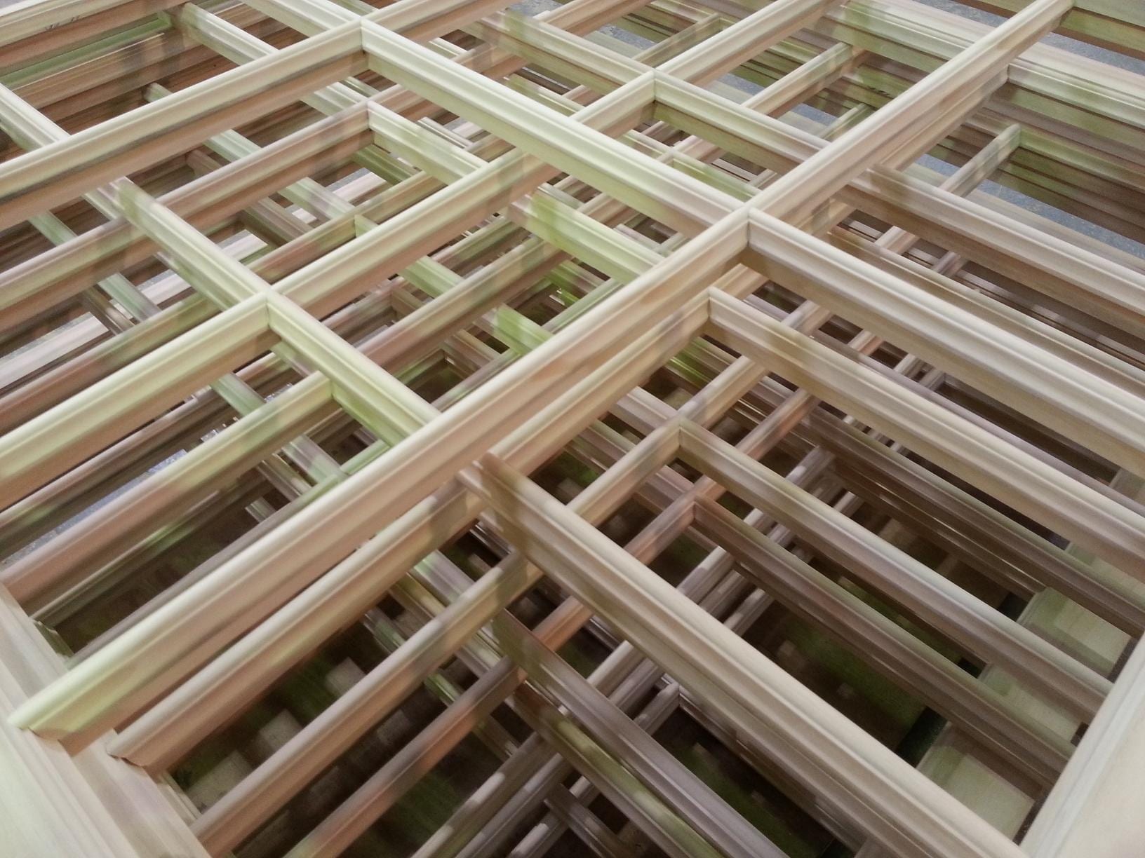 A large amount of wooden window frames ready for paint and glass