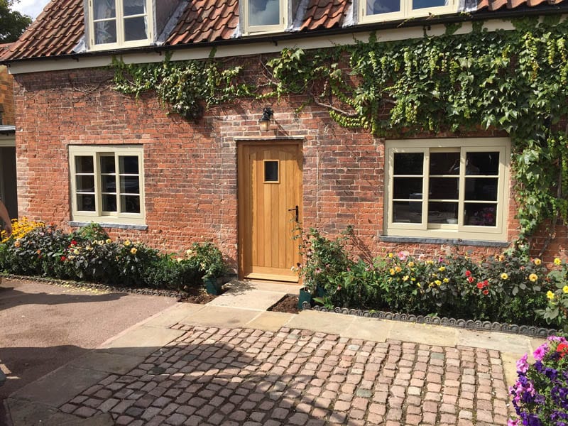 Horizontal sliding sash heritage windows and oak door in listed building restoration by Gowercroft Joinery