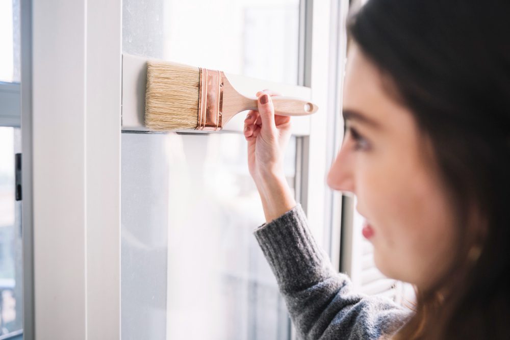 Pretty woman painting a sustainable window