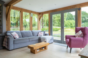 Oak framed living room with bespoke timber framed floor to ceiling windows and French doors.
